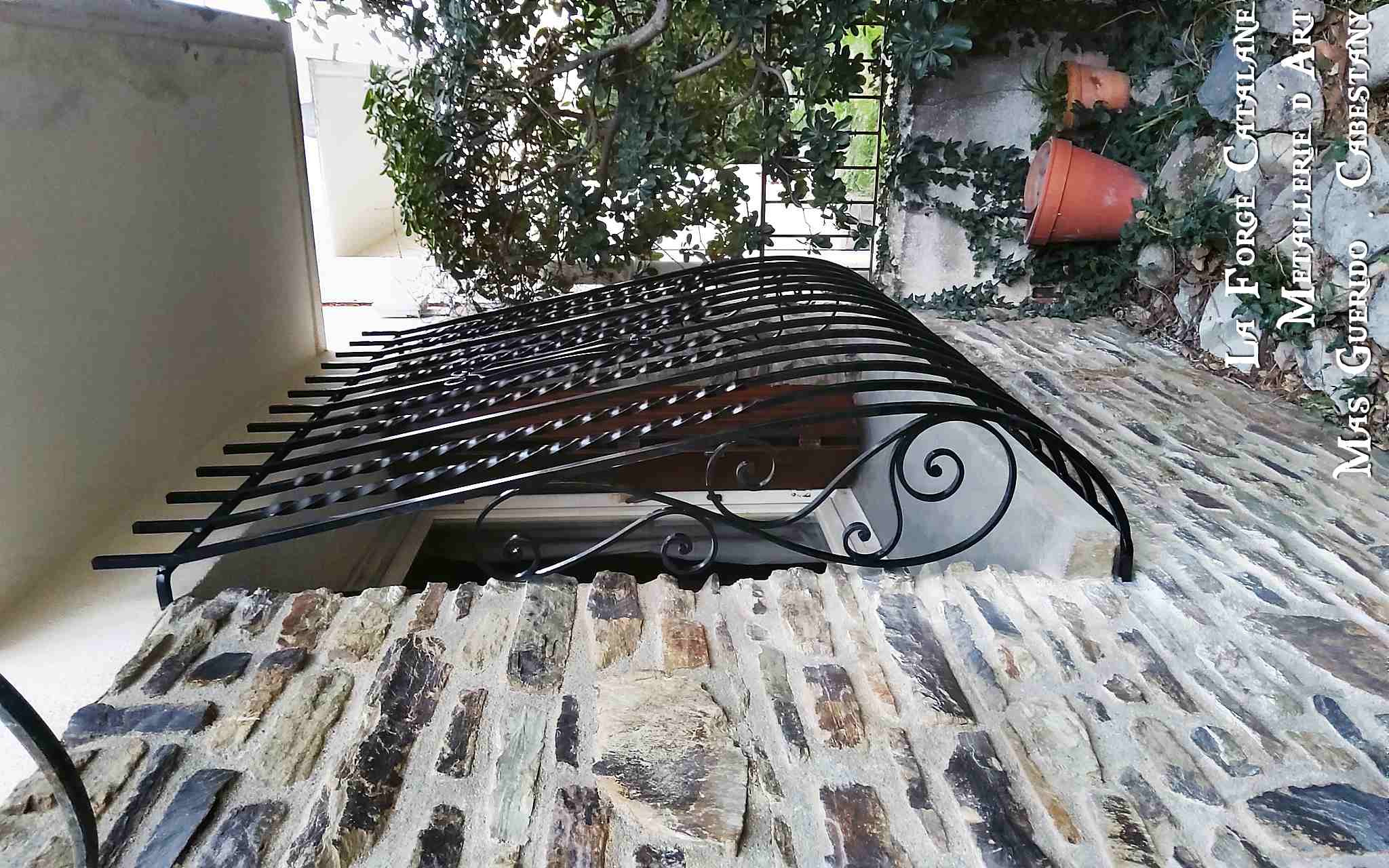 grille de protection galbee ouvragee volutes et barreaux torsade forge catalane.jpg